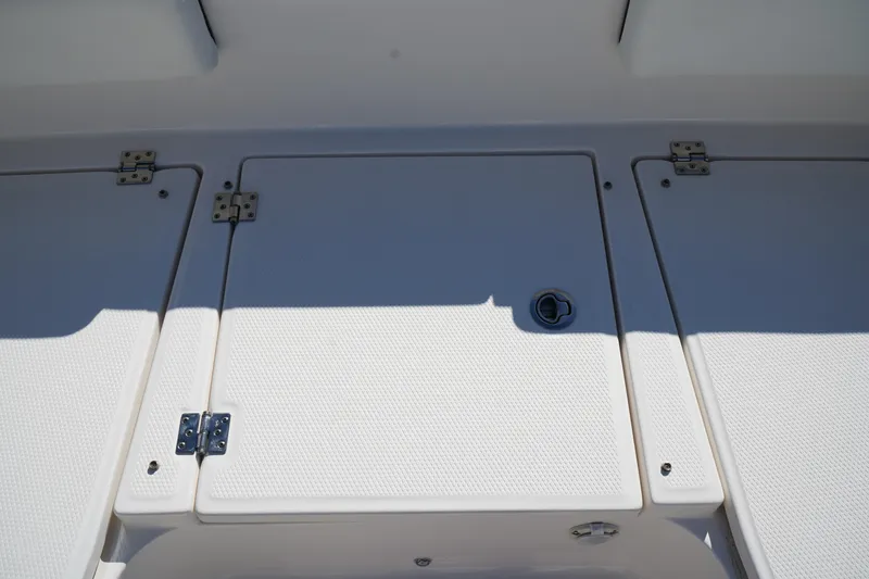 Slide: The Image of 2023 Robalo 266 Cayman boat deck with storage compartments and textured surface. - 39