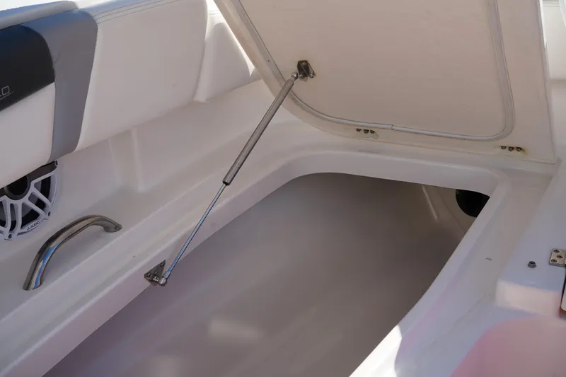 Slide: The Image of 2023 Robalo 266 Cayman boat storage compartment with open hatch and speaker. - 60