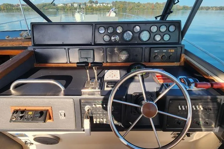 Slide: The Image of 1988 Sea Ray 390 Express Cruiser interior with helm seat and nautical-themed decor. - 11