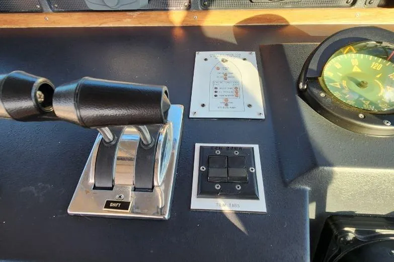 Slide: The Image of 1988 Sea Ray 390 Express Cruiser helm with gauges and steering wheel on calm water. - 12