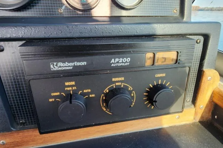 Slide: The Image of 1988 Sea Ray 390 Express Cruiser dashboard with throttle, trim tabs, and compass. - 13