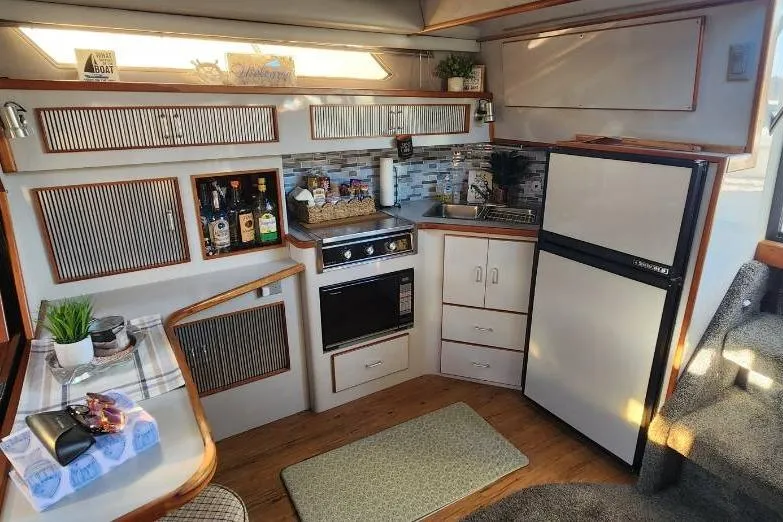 Slide: The Image of Interior of 1988 Sea Ray 390 Express Cruiser with cozy seating and nautical decor. - 17