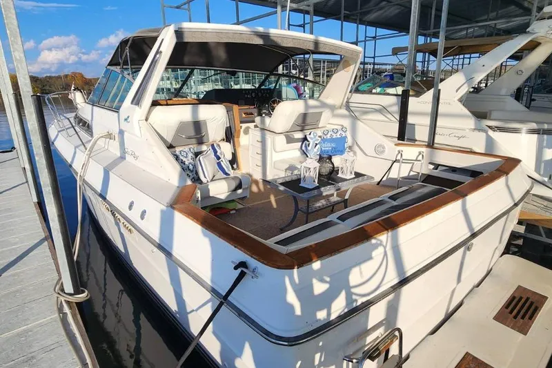 Slide: The Image of 1988 Sea Ray 390 Express Cruiser docked, featuring spacious seating and elegant design. - 2