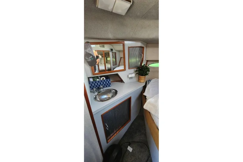 Slide: The Image of Cozy cabin interior of 1988 Sea Ray 390 Express Cruiser with skylight and plush bedding. - 29