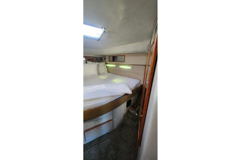 Slide: The Image of 1988 Sea Ray 390 Express Cruiser cabin interior with mirrored closet and cozy bedding. - 31