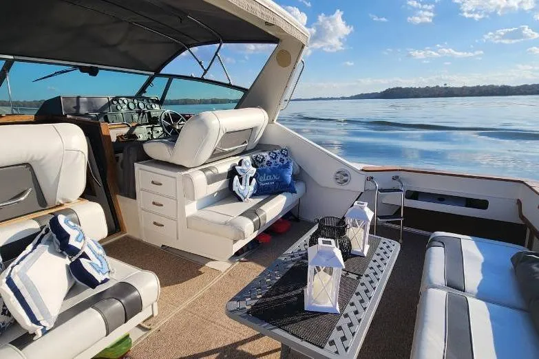 Slide: The Image of 1988 Sea Ray 390 Express Cruiser interior with lake view, featuring comfortable seating and nautical decor. - 7