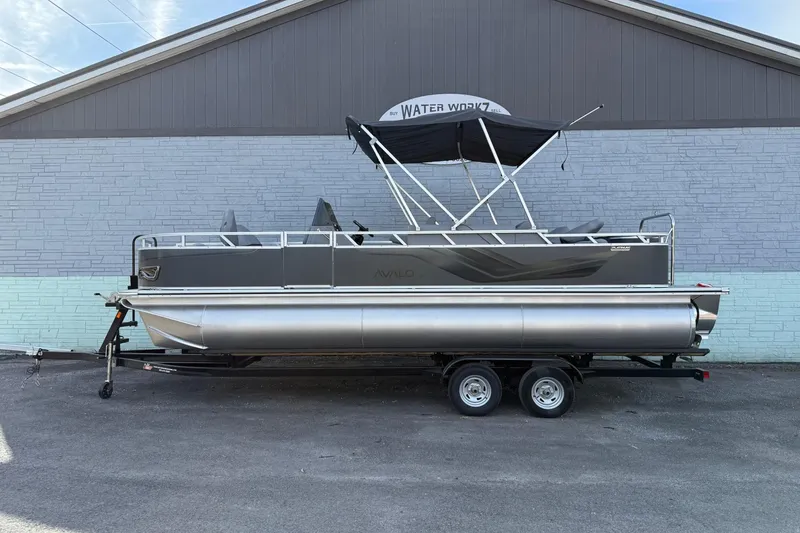 The Image of 2026 Avalon 2385 Venture 85 Center Fish pontoon boat on trailer, parked outdoors. - 1