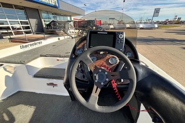 Slide: The Image of 2002 Stratus 18xl boat dashboard with steering wheel and navigation equipment. - 18