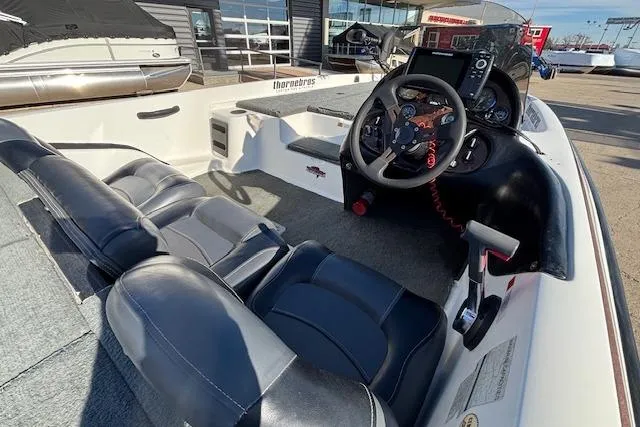 Slide: The Image of 2002 Stratus 18xl boat interior with steering wheel and seating, parked outdoors. - 19