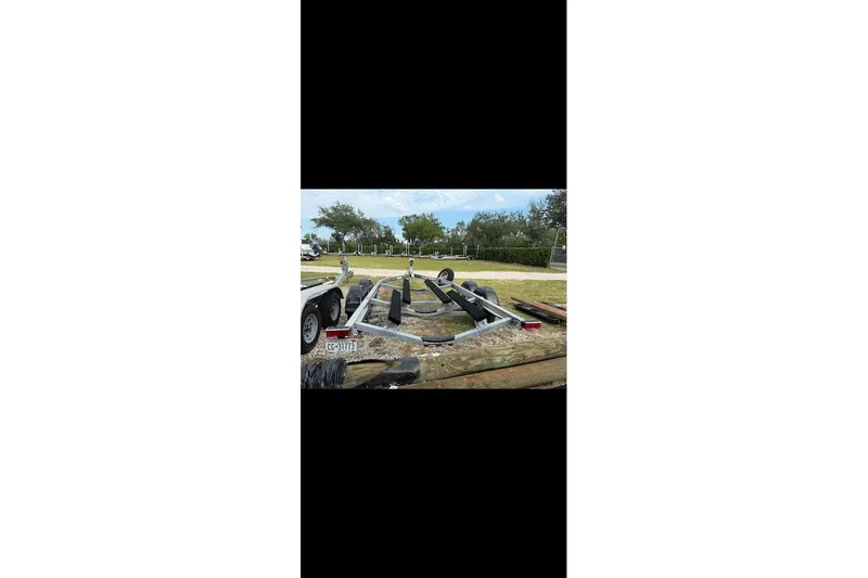 Slide: The Image of Trailer for 2024 Yamaha Boats 222 FSH Sport E, parked outdoors. - 25