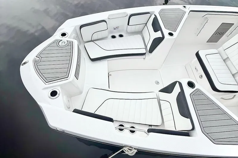 Slide: The Image of 2024 Yamaha Boats 222 FSH Sport E interior with white cushioned seating and storage compartments. - 4