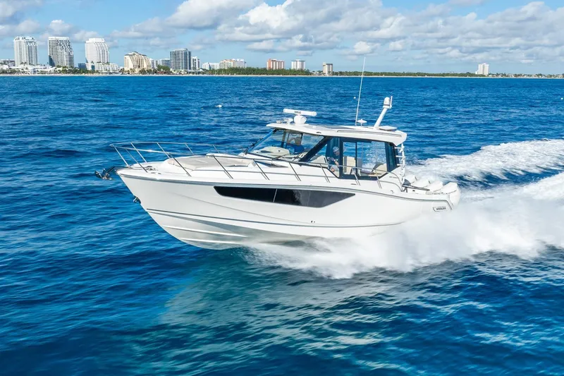 The Image of 2024 Boston Whaler 405 Conquest cruising on blue ocean near city skyline. - 0