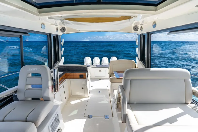 Slide: The Image of 2024 Boston Whaler 405 Conquest interior with ocean view, featuring luxurious seating and modern design. - 15