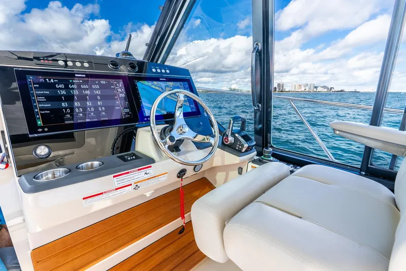 Slide: The Image of 2024 Boston Whaler 405 Conquest helm with advanced navigation system and ocean view. - 17