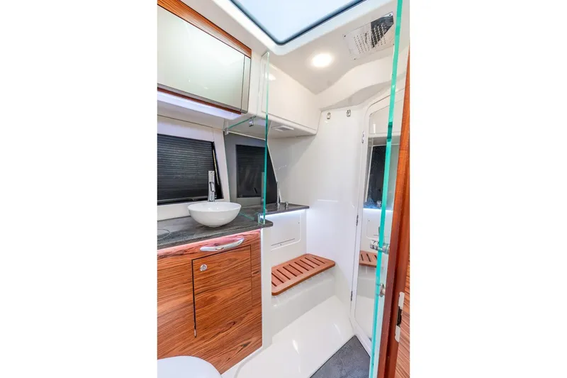 Slide: The Image of Luxurious bathroom interior of 2024 Boston Whaler 405 Conquest boat, featuring modern fixtures and wood accents. - 35