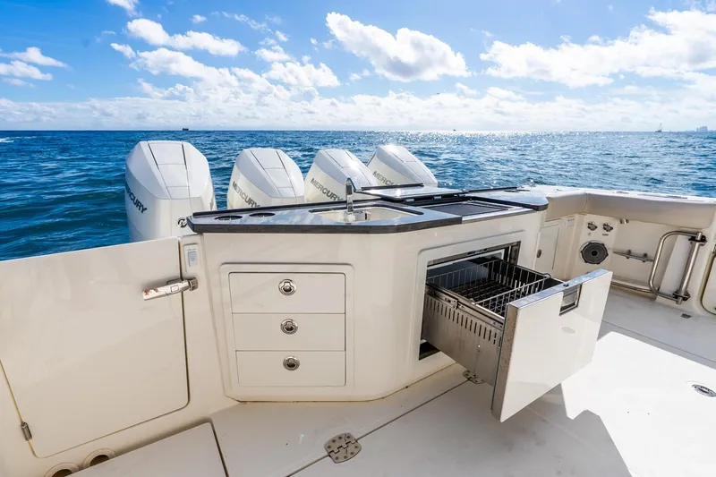 Slide: The Image of 2024 Boston Whaler 405 Conquest boat with open storage, ocean view, and Mercury engines. - 39