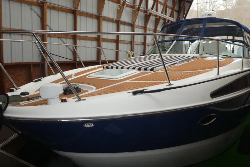 The Image of 2007 Bayliner 325 boat with wooden deck, docked indoors. - 0