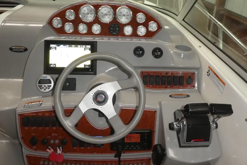 Slide: The Image of 2007 Bayliner 325 boat dashboard with steering wheel, gauges, and navigation controls. - 11