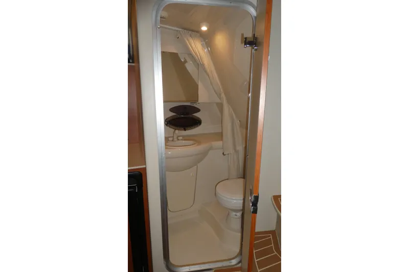 Slide: The Image of 2007 Bayliner 325 boat bathroom with sink, toilet, and shower curtain. - 24