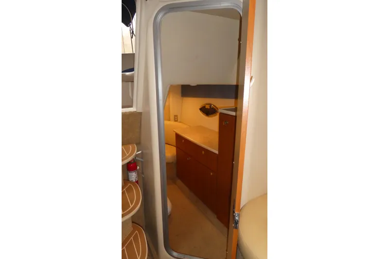 Slide: The Image of Interior cabin view of a 2007 Bayliner 325 boat, featuring wooden cabinetry and seating. - 26