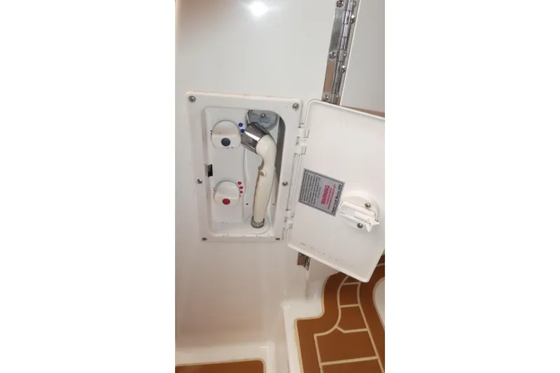 Slide: The Image of 2007 Bayliner 325 boat shower controls with open hatch and temperature dials. - 31