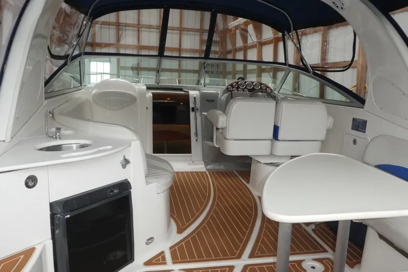 Slide: The Image of 2007 Bayliner 325 boat interior with seating, helm, and kitchenette area. - 6