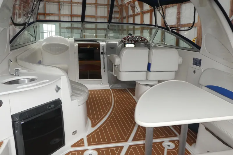 Slide: The Image of Interior of a 2007 Bayliner 325 boat with seating, table, and helm. - 9