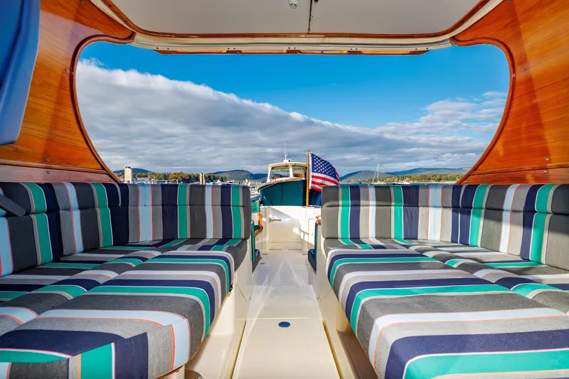 Slide: The Image of Interior view of 1999 Hinckley Talaria 44 Express yacht with striped seating and scenic ocean backdrop. - 20