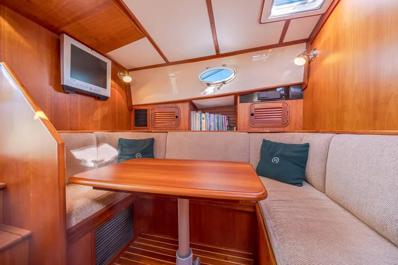 Slide: The Image of Interior of 1999 Hinckley Talaria 44 Express yacht with cozy seating and wooden table. - 28