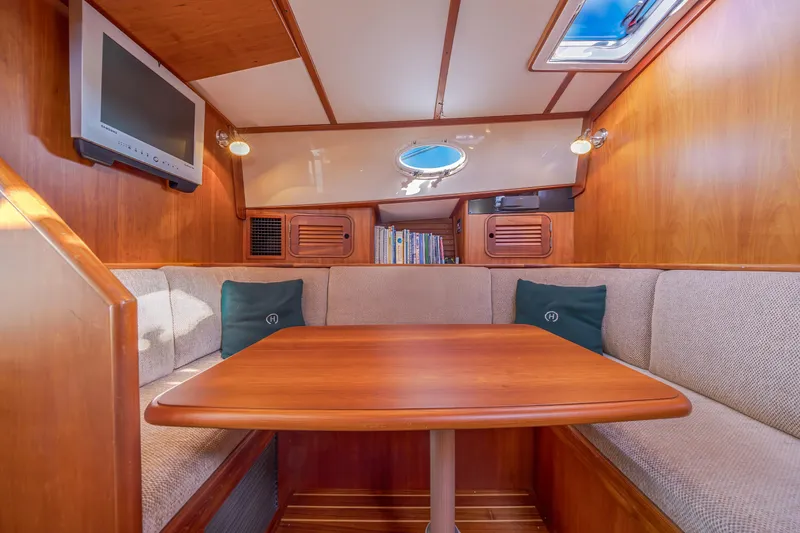 Slide: The Image of Interior of 1999 Hinckley Talaria 44 Express with cozy seating and wooden table. - 29