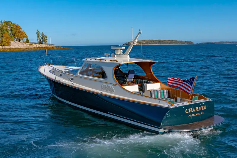 Slide: The Image of 1999 Hinckley Talaria 44 Express yacht cruising in scenic coastal waters. - 3
