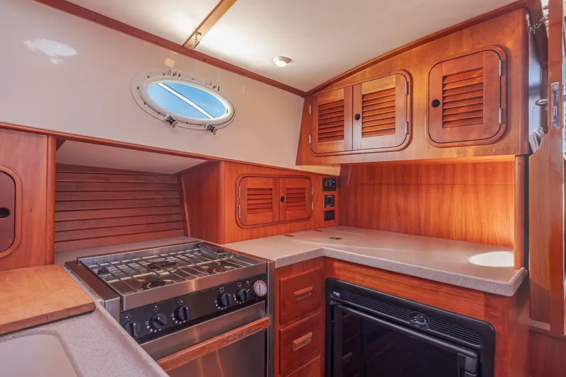 Slide: The Image of Interior of 1999 Hinckley Talaria 44 Express yacht kitchen with wooden cabinetry and stove. - 34