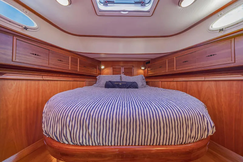 Slide: The Image of Luxurious cabin interior of 1999 Hinckley Talaria 44 Express yacht with striped bedding. - 37