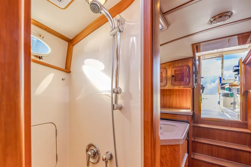 Slide: The Image of Interior of 1999 Hinckley Talaria 44 Express yacht, featuring a shower and wooden cabinetry. - 45