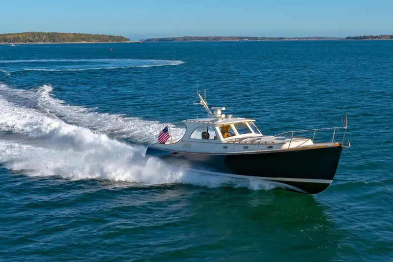 Slide: The Image of 1999 Hinckley Talaria 44 Express cruising on open water, showcasing sleek design and performance. - 7