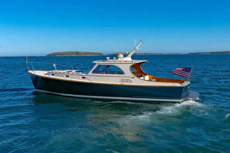 Slide: The Image of 1999 Hinckley Talaria 44 Express yacht cruising on open water under clear blue skies. - 9