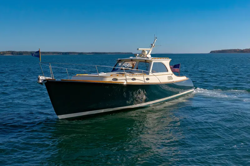 Slide: The Image of 1999 Hinckley Talaria 44 Express yacht cruising on open water under clear blue skies. - 10