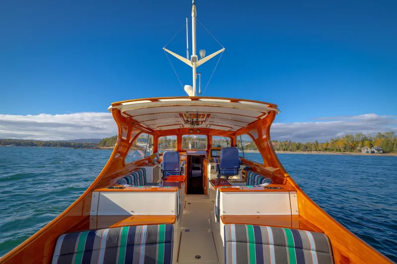 Slide: The Image of 1999 Hinckley Talaria 44 Express yacht on scenic water with clear blue sky. - 14