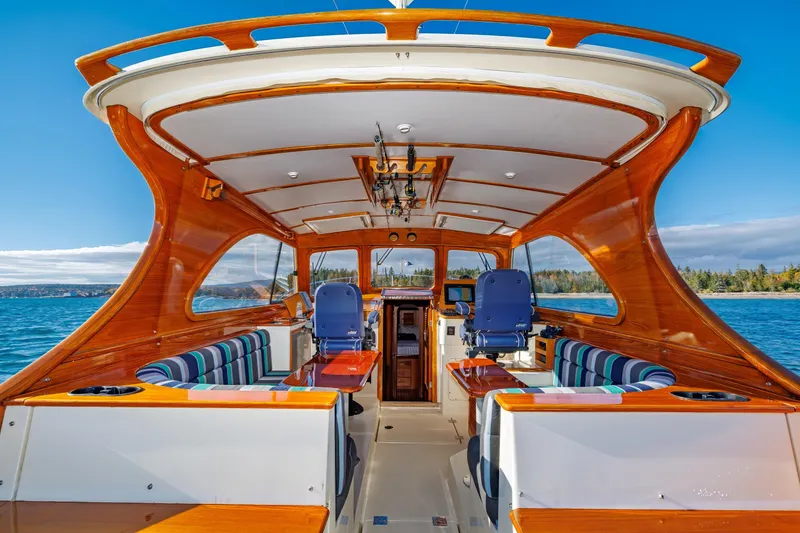 Slide: The Image of Hinckley Talaria 44 Express 1999 yacht interior with polished wood and striped seating. - 15