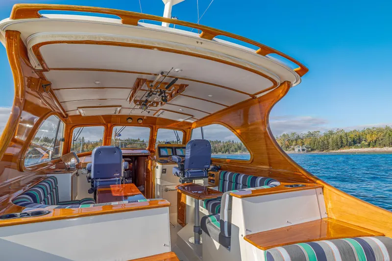 Slide: The Image of 1999 Hinckley Talaria 44 Express yacht interior with polished wood and striped seating. - 16