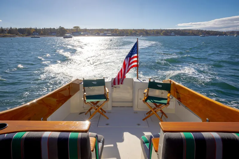 Slide: The Image of Hinckley Talaria 44 Express 1999 cruising on sunny waters with American flag. - 19