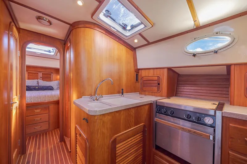 Slide: The Image of Interior of 1999 Hinckley Talaria 44 Express yacht with wood finish and kitchen amenities. - 30