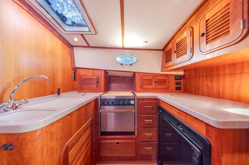 Slide: The Image of Interior of 1999 Hinckley Talaria 44 Express yacht kitchen with wood cabinetry and modern appliances. - 32