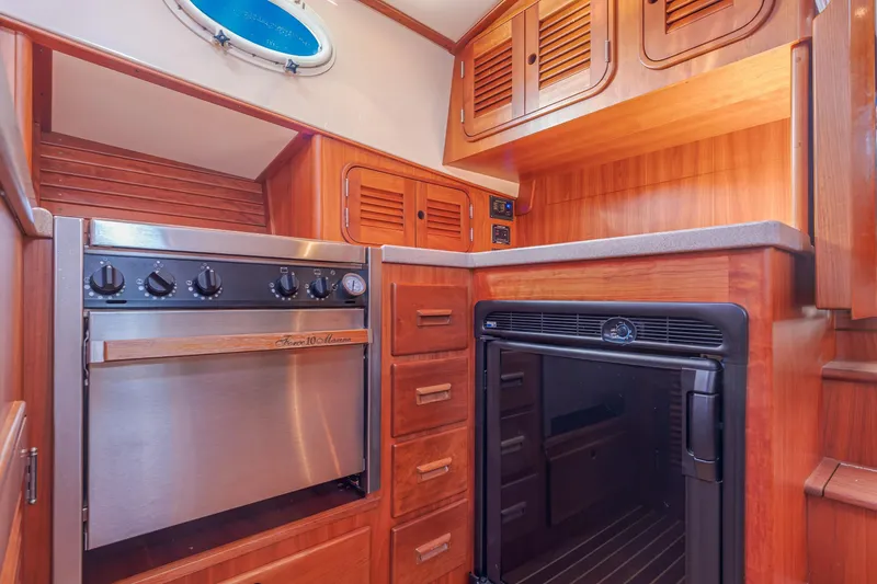 Slide: The Image of Hinckley Talaria 44 Express 1999 yacht kitchen with wood cabinetry and stainless steel appliances. - 35