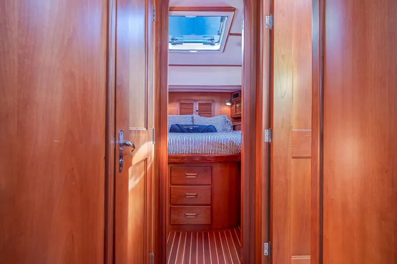 Slide: The Image of Interior of 1999 Hinckley Talaria 44 Express, featuring wooden cabinetry and cozy sleeping quarters. - 36