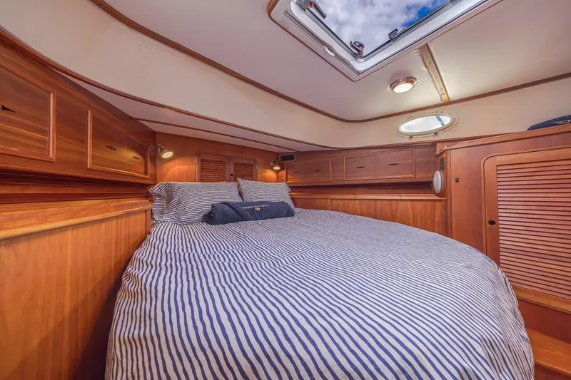 Slide: The Image of Luxurious cabin interior of 1999 Hinckley Talaria 44 Express yacht with striped bedding. - 38