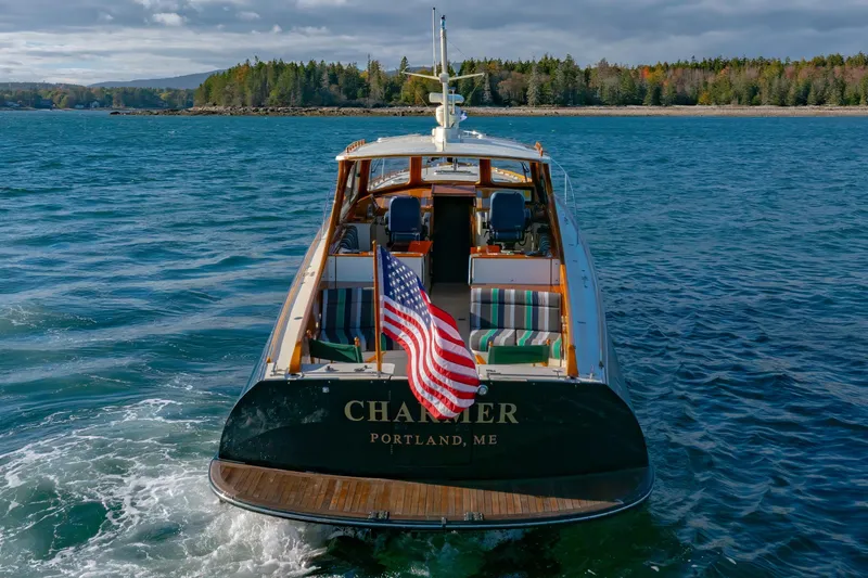 Slide: The Image of Hinckley Talaria 44 Express yacht, 1999, cruising in scenic waters with American flag. - 4