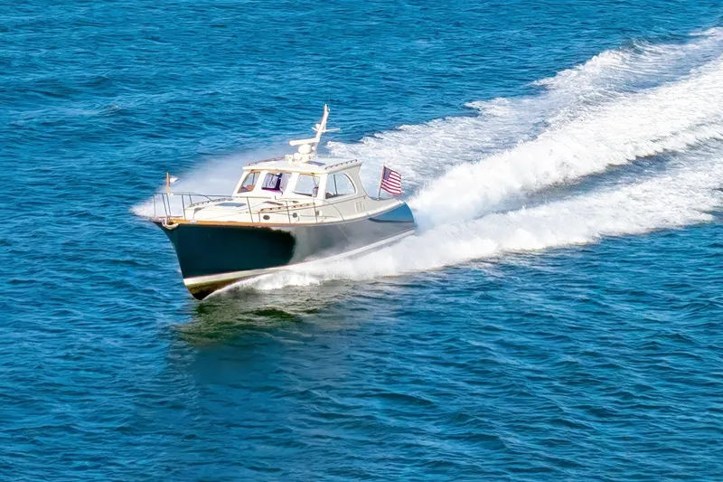 Slide: The Image of 1999 Hinckley Talaria 44 Express cruising on open blue water. - 6