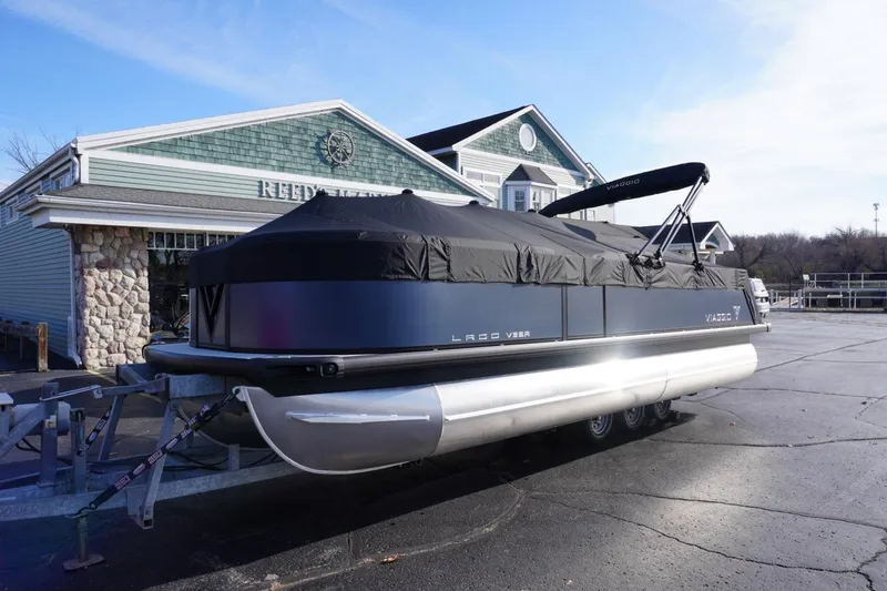 Slide: The Image of 2026 Viaggio Lago V-R pontoon boat with cover, parked at a marina. - 71