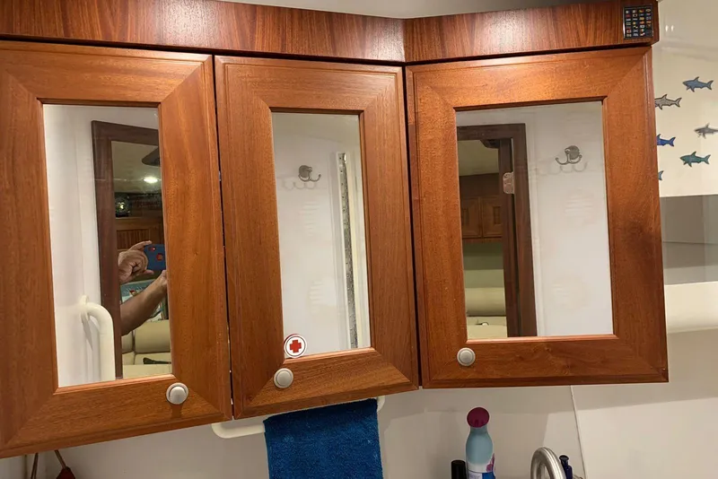 Slide: The Image of Wooden bathroom cabinet with mirrors in a 2015 Jupiter 41 SB boat. - 39